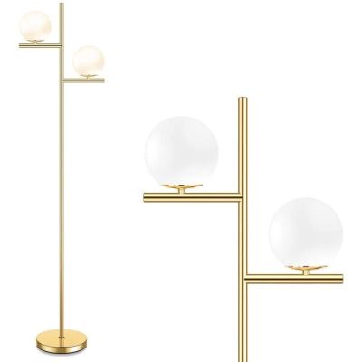 a gold floor lamp with two glass globes on a stand