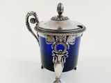a silver and blue vase with a lid on a white background