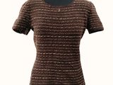 Le haut du t-shirt de cette femme est marron et doré.