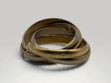 a close up of two gold rings on a white surface