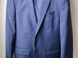 the jacket is blue and has a flower on the lapel