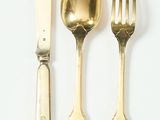 trois fourchettes, une cuillère et un couteau posés sur une surface blanche