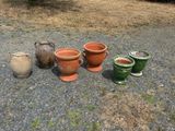 four different pots sitting on the ground next to each other