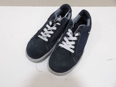 baskets en daim bleu marine avec des lacets blancs sur un fond blanc
