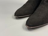 a close up of a pair of black sued boots on a white surface
