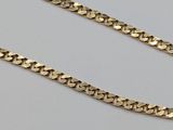 a close up of a gold chain on a white surface