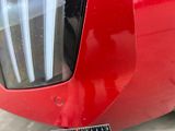 a close up of a red car with a sticker on it