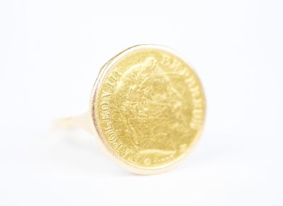 a close up of a gold coin ring on a white surface