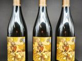 trois bouteilles de vin posées sur une table en bois
