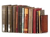 several old books are lined up in a row on a white surface