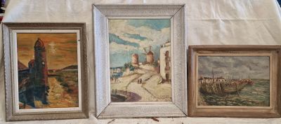 trois tableaux posés sur une table recouverte d'une nappe blanche