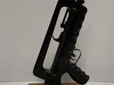 un petit pistolet jouet posé sur un socle en bois, lui-même posé sur une surface blanche