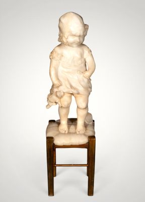 statue of a child sitting on a stool with a teddy bear