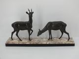pair of bronze deer sculptures on marble base on white background