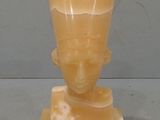 a yellow vase with a face on it on a stand