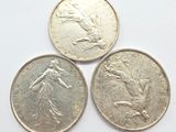 three british coins sitting on top of each other on a white surface