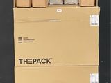des cartons empilés les uns sur les autres sur une palette devant un mur noir