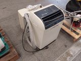 un petit climatiseur posé sur une palette dans un entrepôt