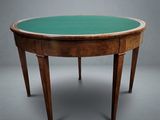 an oval table with a green glass top and wooden legs