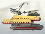 trois trains miniatures assis l'un à côté de l'autre sur une table