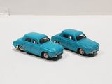 two toy cars that are sitting on a white surface
