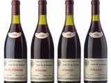 three bottles of red wine are lined up on a white surface