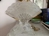 un vase en verre posé sur une table en marbre, avec un miroir en arrière-plan