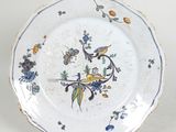 une assiette blanche décorée de fleurs bleues et jaunes