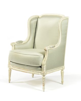 une chaise blanche dont le dossier et les accoudoirs sont recouverts de tissu beige