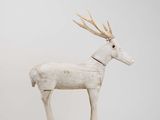 sculpture of a white deer with antlers on it ' s head