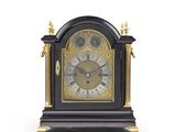 une horloge noire et or posée sur une surface blanche