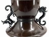 a brown vase with two dragon handles on it