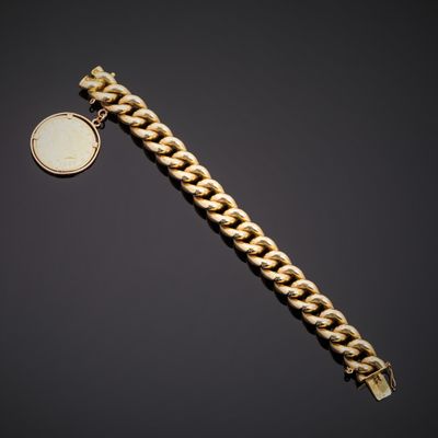 un bracelet en or orné d'une pièce de monnaie sur fond noir