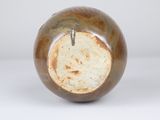 a brown vase with a hole in it on a white surface