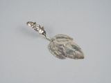 une cuillère en argent ornée d'une feuille, posée sur une table
