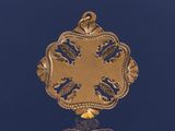 un pendentif en or orné d'un motif sur un fond bleu