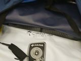 a bag with a camera attached to it and a cell phone in it