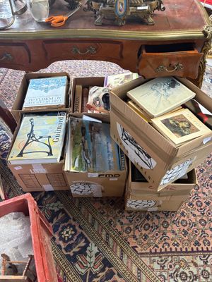 de nombreuses caisses de livres posées par terre à côté d'une table