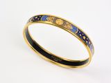 un gros plan sur un bracelet rigide en émail doré et bleu