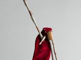a red bag with a pair of knitting needles hanging from it