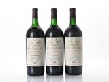 three bottles of wine are lined up on a white surface