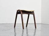 an image of a wooden stool with a yellow cushion on top of it