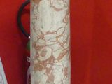 a marble pedestal in front of a red wall