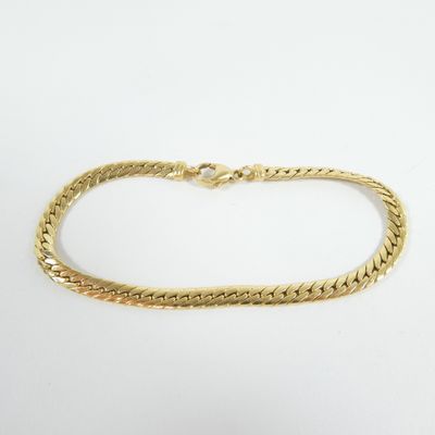 a gold bracelet with a braid design on a white background
