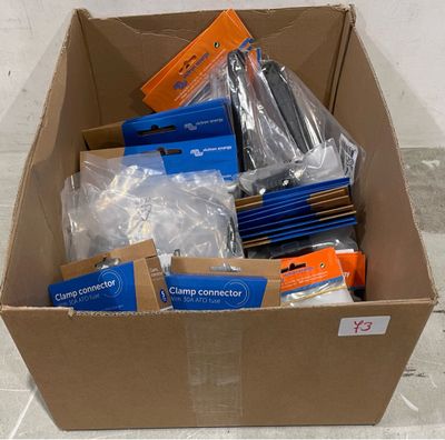 une boîte en carton remplie d'objets divers, posée par terre