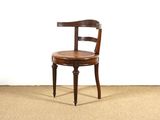 une chaise en bois avec une assise en cuir, posée sur un sol recouvert de moquette