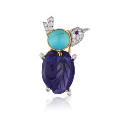 un gros plan d'une broche en forme d'oiseau sertie d'une pierre bleue et de diamants