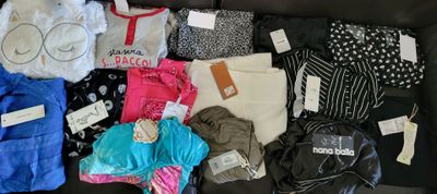 a lot of clothes that are sitting on a couch