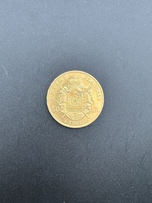 gros plan d'une pièce d'or sur une surface noire