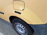 a close up of a yellow van parked in a parking lot